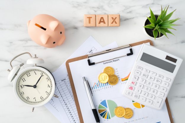 Top view of calculating and paying tax concept on marble white table. Retirement Communities In Kansas: Understanding Your Taxes