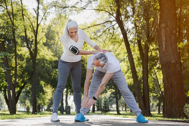 Full length of active senior couple doing warm up exercises Full length of active senior couple doing warm up exercises