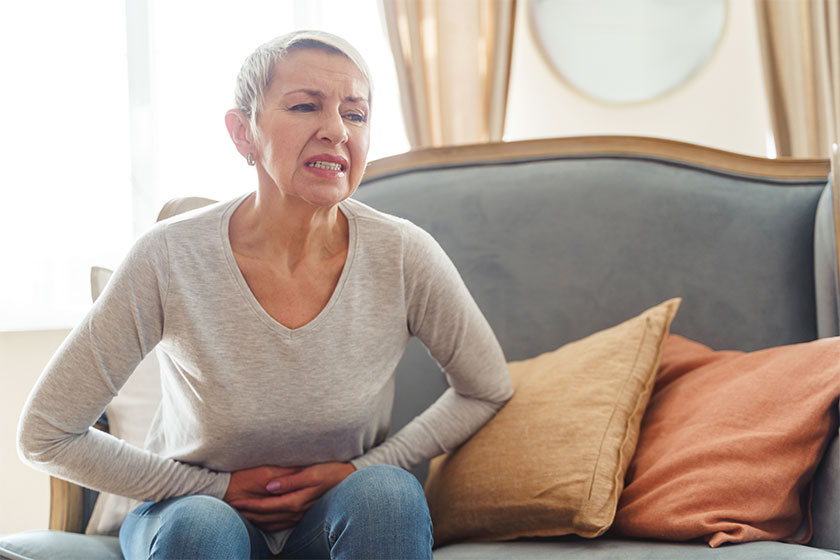 Modern senior woman experiencing severe stomach spasms Modern senior woman experiencing severe stomach spasms