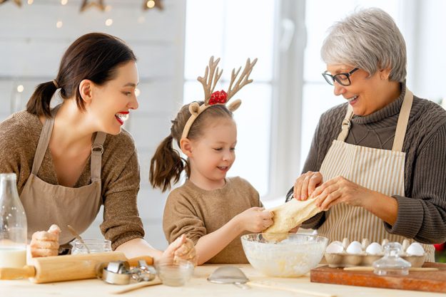 Merry Christmas and Happy Holidays. Family preparation holiday food. Grandma, mother and daughter cooking cookies. Merry Christmas and Happy Holidays. Family preparation holiday food. Grandma, mother and daughter cooking cookies.