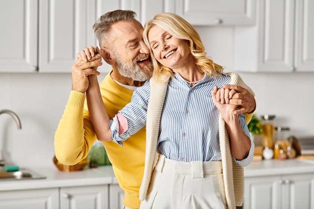 A-mature-loving-couple-dressed-in-cozy-homewear-dancing