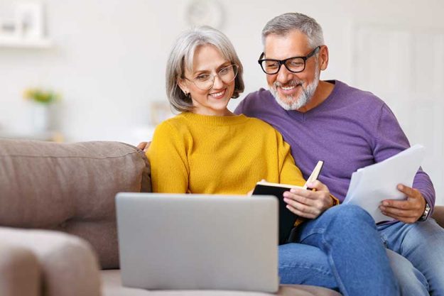 Happy-senior-couple-reading-good-news-in-letter-while-paying