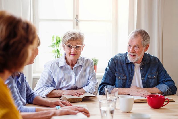 Senior-people-in-bible-reading-group-in-community-center- Senior-people-in-bible-reading-group-in-community-center-