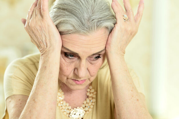 Portrait of a sad elderly woman posing at home